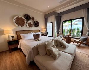 查汶Baan Haad Ngam Boutique Resort的一间卧室配有一张大床和一张沙发