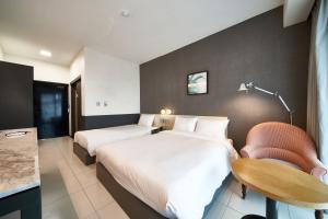 西归浦市Lareem Boutique Hotel的酒店客房,配有两张床和椅子