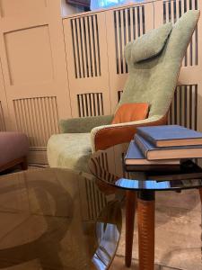 佛罗伦萨尼泽酒店的客厅配有椅子和桌子及书籍