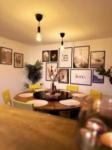 纳克斯考Slava Hygge House的墙上设有餐桌和图片的餐厅