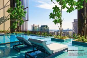 新加坡Oasia Hotel Downtown, Singapore by Far East Hospitality的一座带两把躺椅的游泳池