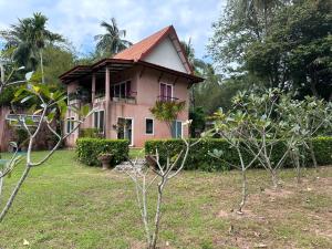 俊穆岛Piman Pu的前面有树木的粉红色房子