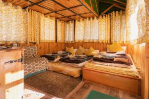 德拉敦Kanasar Jungle Camp & Retreat的一间带两张床的卧室,位于带窗帘的房间