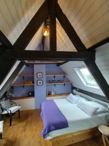 SimeyrolsLes Bernardies的阁楼卧室设有床和窗户。