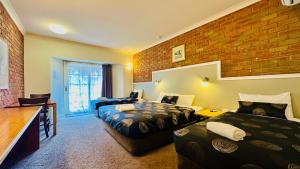米尔迪拉澳大利亚厄尔利汽车旅馆的酒店客房带两张床和砖墙