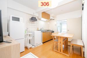 东京Downtown Apartment/ SHIBUYA Station 10mins on foot的厨房以及带桌子和冰箱的用餐室