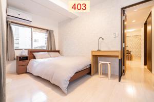 东京Downtown Apartment/ SHIBUYA Station 10mins on foot的一间卧室配有一张床、一张桌子和一个水槽