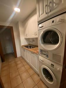 仕格莱Casa los 8 caños的厨房配有洗衣机、烘干机和水槽