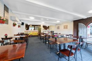 珀斯Econo Lodge Rivervale的用餐室配有木桌和椅子