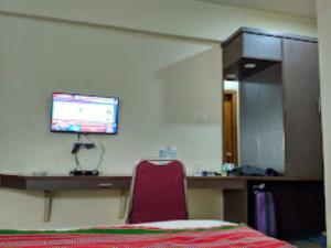 因帕尔Hotel Yaiphabaa , Imphal的客房设有书桌和墙上的电视。