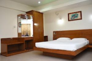因帕尔Hotel Yaiphabaa , Imphal的一间卧室配有一张大床和镜子