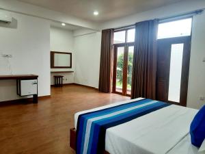 米瑞莎Hemalie Resort Mirissa的一间卧室设有一张床和一个大窗户