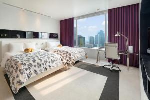 曼谷曼谷 W 酒店 的酒店客房设有两张床和窗户。