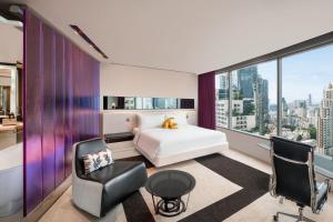 曼谷曼谷 W 酒店 的卧室配有一张床、一张桌子和椅子