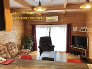 八户市青森伝統芸能を楽しめる繭子の宿的客厅设有桌子和大窗户