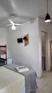 特林达德PANTAI Casa e Pousada的白色卧室配有床和吊扇