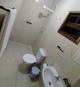 特林达德PANTAI POUSADA的白色的浴室设有卫生间和水槽。