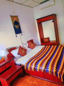 琅勃拉邦天堂鸟花园客栈的一间卧室配有一张带镜子和灯的床