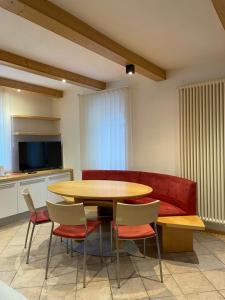 坎皮泰洛迪法萨Appartamento Rio Duron的配有桌椅和红色沙发的房间