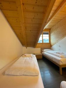 坎皮泰洛迪法萨Appartamento Rio Duron的配有木天花板的客房内的两张床