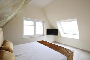 诺德代希Seeblick 3的一间白色卧室,配有床和2个窗户