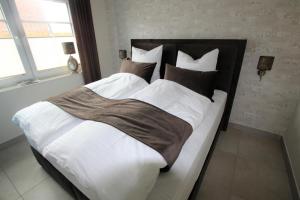 诺德代希Seeblick 6 - Traumferien am Hafen的卧室配有一张带白色床单和枕头的大床。