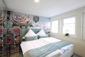 诺德代希Seeblick 2的卧室配有一张墙上鲜花的床
