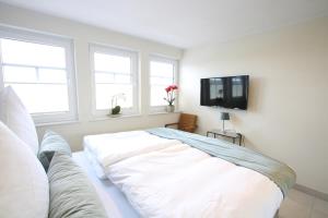 诺德代希Seeblick 2的白色的客房设有沙发和电视。