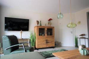 诺德代希Seeblick 1的一间带电视和木柜的客厅
