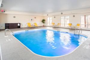 阿什兰阿什兰费尔菲尔德客栈套房酒店的一个带黄色椅子的房间的大型游泳池
