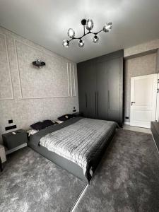 YalanghochCialkovsky new and modern Apt !的一间卧室配有一张大床和一个吊灯。