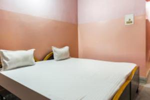 克塔克Indra Bhawan Lodge, Cuttack的卧室配有一张带两个枕头的大白色床