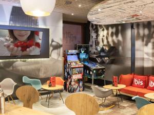 马德里Ibis Madrid Aeropuerto Barajas的客房设有桌椅和平面电视。