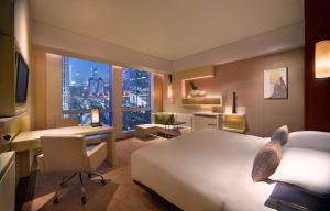 广州广州富力君悦大酒店的酒店客房配有一张床、一张书桌和一张书桌。