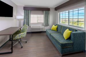 圣罗莎La Quinta by Wyndham Santa Rosa的客厅配有沙发、桌子和黄色枕头