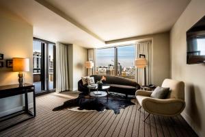 芝加哥Thompson Chicago, by Hyatt的带沙发和椅子的客厅以及大窗户。