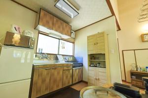 SaikuboSunland S45 - Vacation STAY 45835v的厨房配有木制橱柜和白色冰箱。