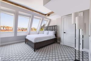 华盛顿Georgetown Residences by LuxUrban的一间卧室配有一张带白色床单和窗户的床。