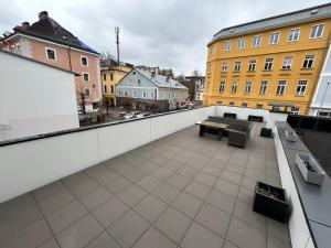 格蒙登Ferienwohnung Gmunden City的阳台享有长凳和建筑的景致。