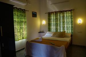 马拉利库兰Marari Anns Casa Beach Homestay的一间卧室设有一张床和两个窗户。