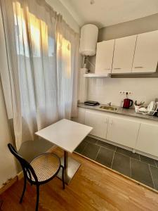 沙勒罗瓦Studio comfortable charleroi的白色的厨房配有桌子、椅子和柜台