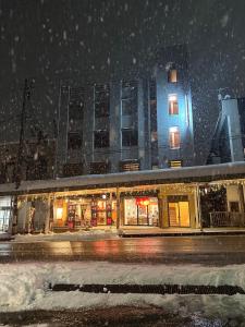 汤泽町駅本ビル民宿的雪中城市街道上的建筑
