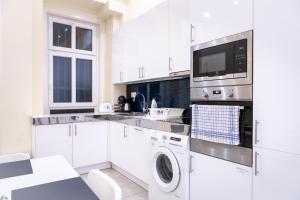布达佩斯Erzsebet19 Apartment的白色的厨房配有洗衣机和烘干机