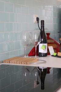 VignanelloHome Sweet Home的柜台上的一瓶葡萄酒和两杯酒杯