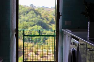 VignanelloHome Sweet Home的厨房的窗户享有树木的景致