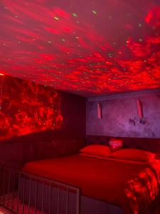泰拉奇纳Sweetlove Spa的天花板上设有红色灯光的卧室