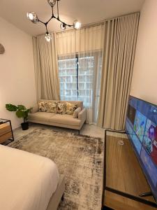 Al QurayyahModern Home的一间配有沙发的卧室和客房内的电视