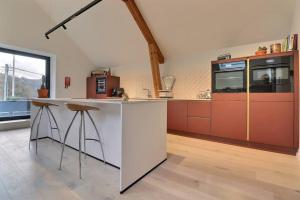 普罗丰德维耶Appartement (8 pers.) design.的厨房配有白色的柜台和红色的橱柜