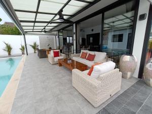 拉威海滩Beautiful private 3 bedroom villa with pool and gym的带沙发和桌子的庭院以及游泳池。