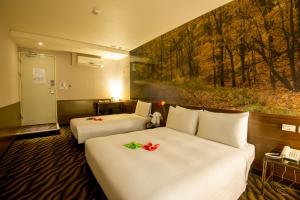 台北陆号行旅万年馆的酒店客房设有两张床,墙上挂有绘画作品